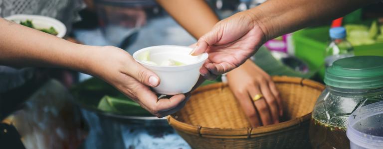 Two pairs of hands hold and reach into food bowls