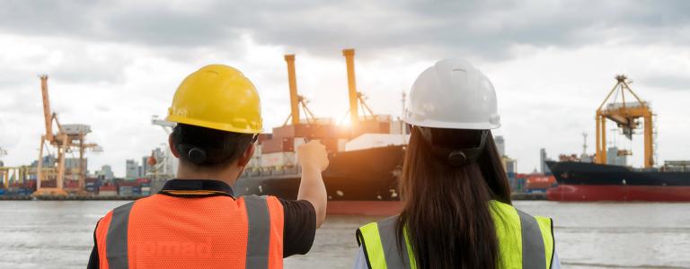 Engineers working together at a shipping port.