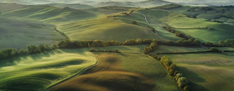 Tuscany landscape at sunrise with low fog.