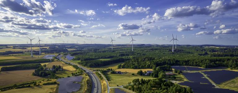 Solar panels and wind turbines across a large landscape