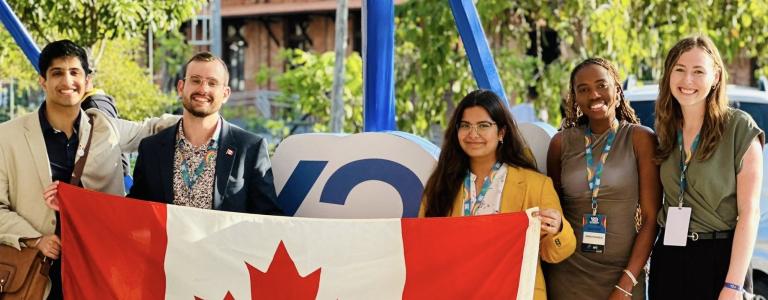 Five young people hold a Canadian flag