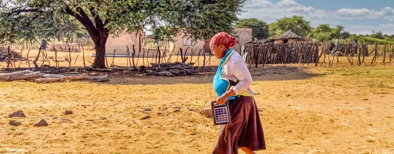Women uses solar panel to charge a radio