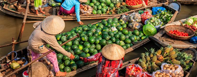 Women sell produce from their boats.