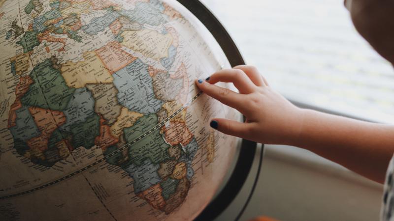 A person touching a globe