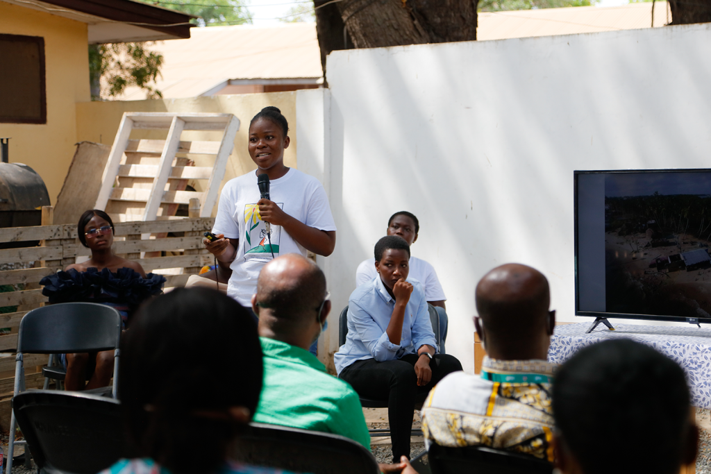 Participant of the Envisioning Resilience initiative at a policy dialogue telling the story behind her photo that shows the impacts of climate change on her life.