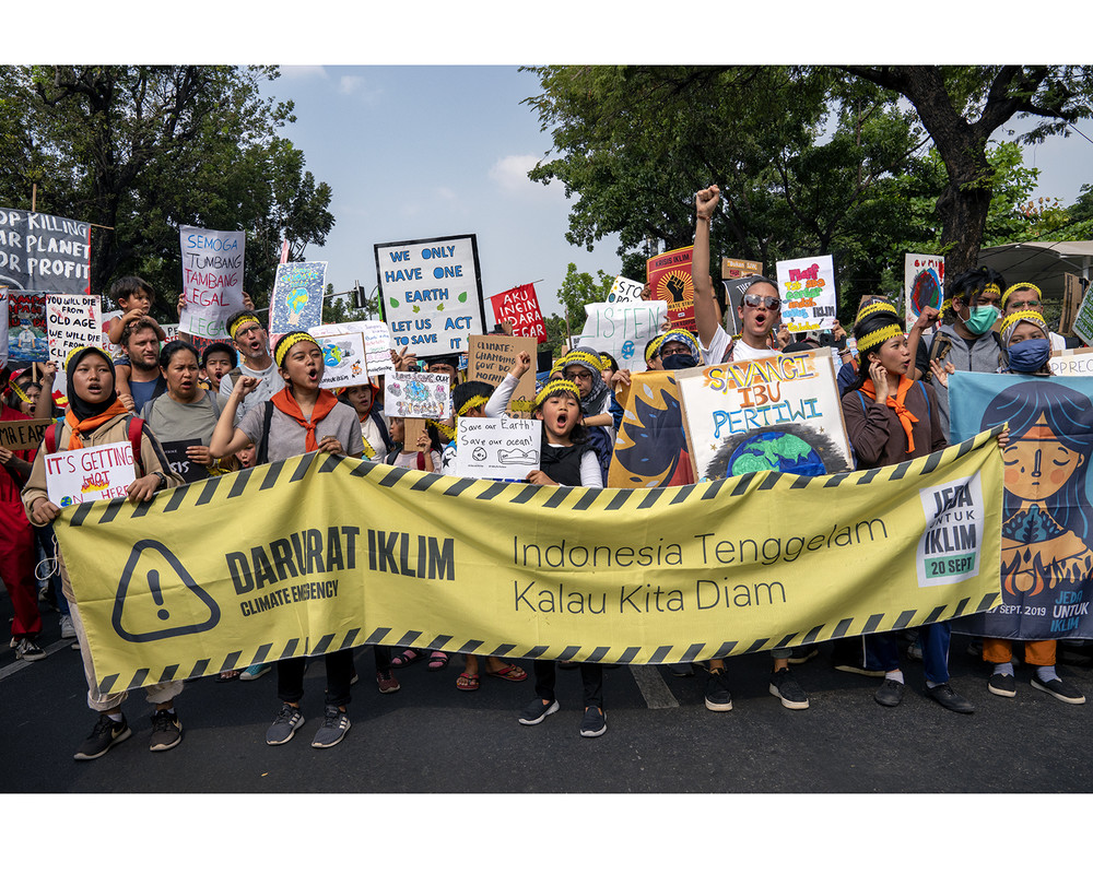 Young protesters in Jakarta, Indonesia, holding up a banner and signs